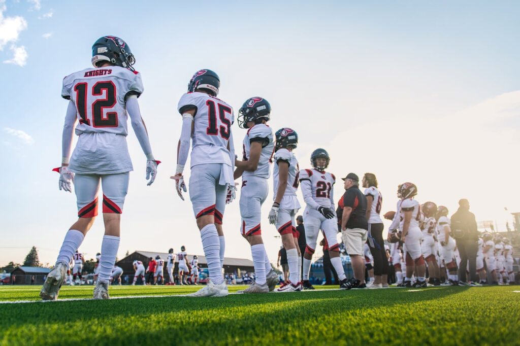 A high school football team lines up on the field, ready for their match.